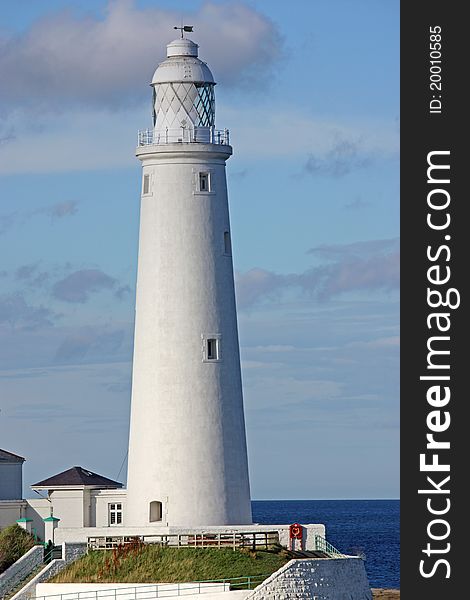 A Traditional Tall British Coastal White Lighthouse.