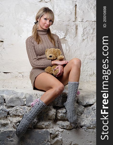 Sexy Girl With Teddy Bear Sitting On Wall