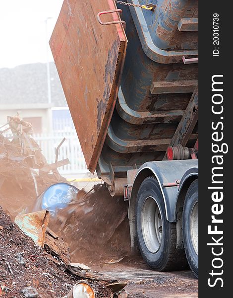 Truck unloading metal rusty scrap in the dock. Truck unloading metal rusty scrap in the dock