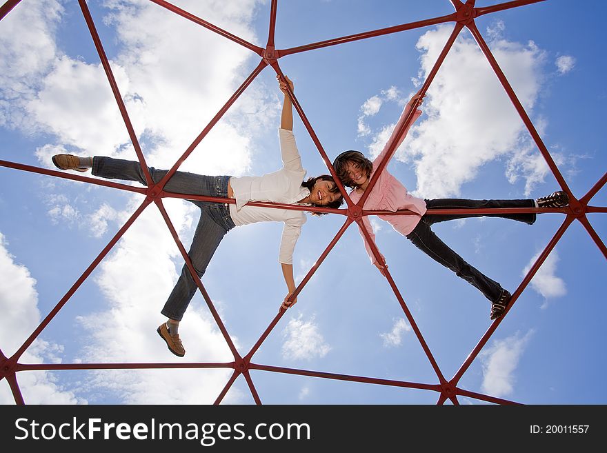 Mother and her daughter up high on the piece of playground equipment. Mother and her daughter up high on the piece of playground equipment.