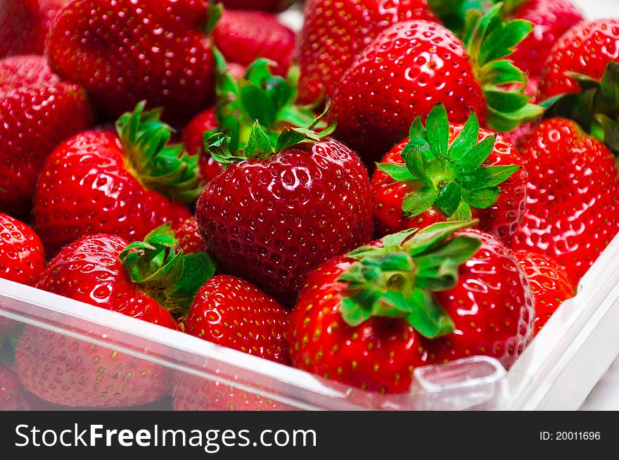 Plastic tray with fresh organic strawberries.