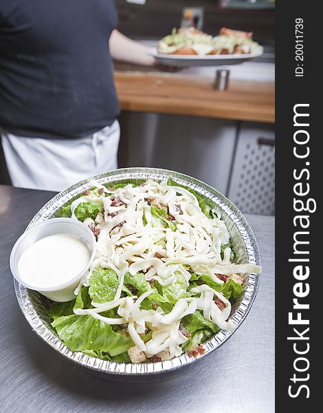 Waiter with take out caesar salad