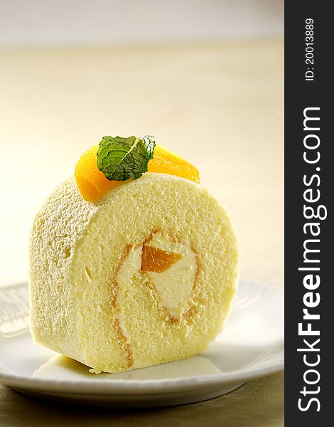 A slice of delisious roll cake toping with fresh peach. A slice of delisious roll cake toping with fresh peach