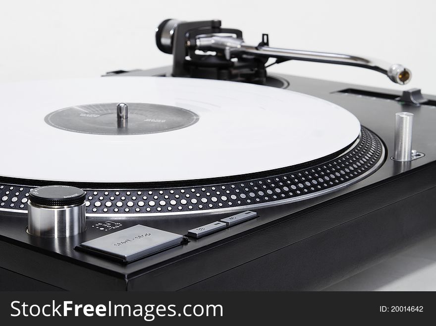 Professional DJ direct-drive turntable record player on white surface. Professional DJ direct-drive turntable record player on white surface