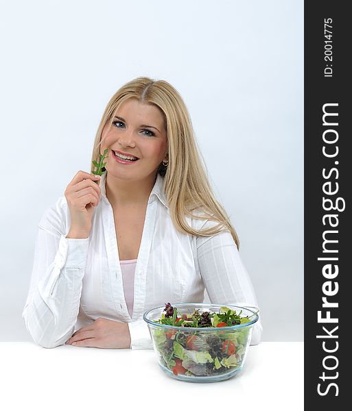 Pretty woman eating green vegetable salad. isolated on white. Pretty woman eating green vegetable salad. isolated on white