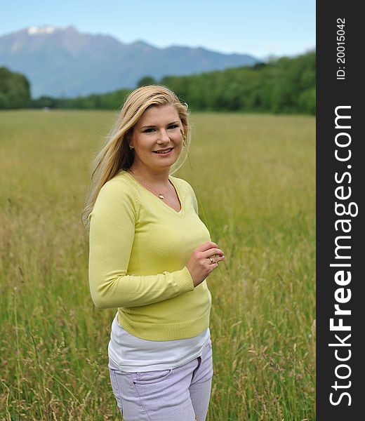 Beautiful natural woman with pure healthy skin outdoors on spring field. Switzerland. Beautiful natural woman with pure healthy skin outdoors on spring field. Switzerland