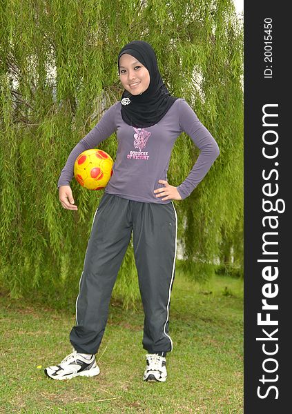 Young woman doing outdoor exercises with ball. Young woman doing outdoor exercises with ball