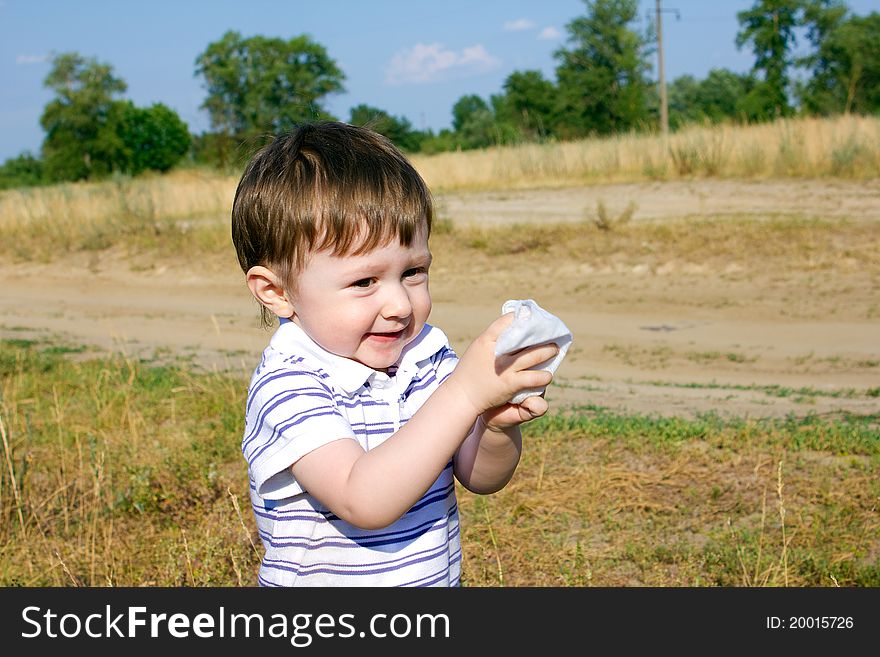 Child after an active game on meadow cleans hands. Child after an active game on meadow cleans hands