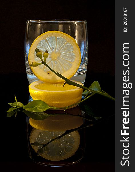 Lemon composition on a black background with reflection on the bottom. Lemon composition on a black background with reflection on the bottom.