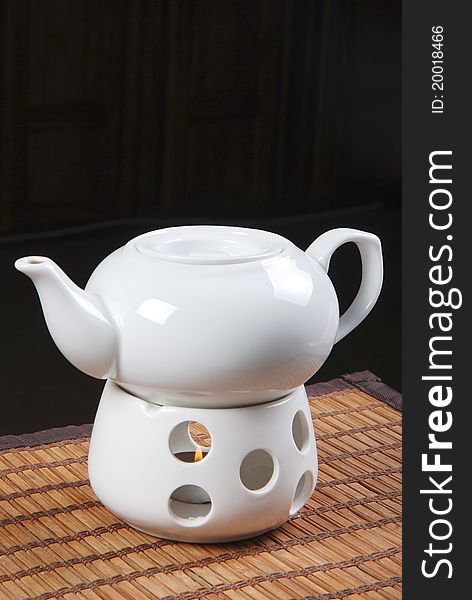 White teapot with candle on table