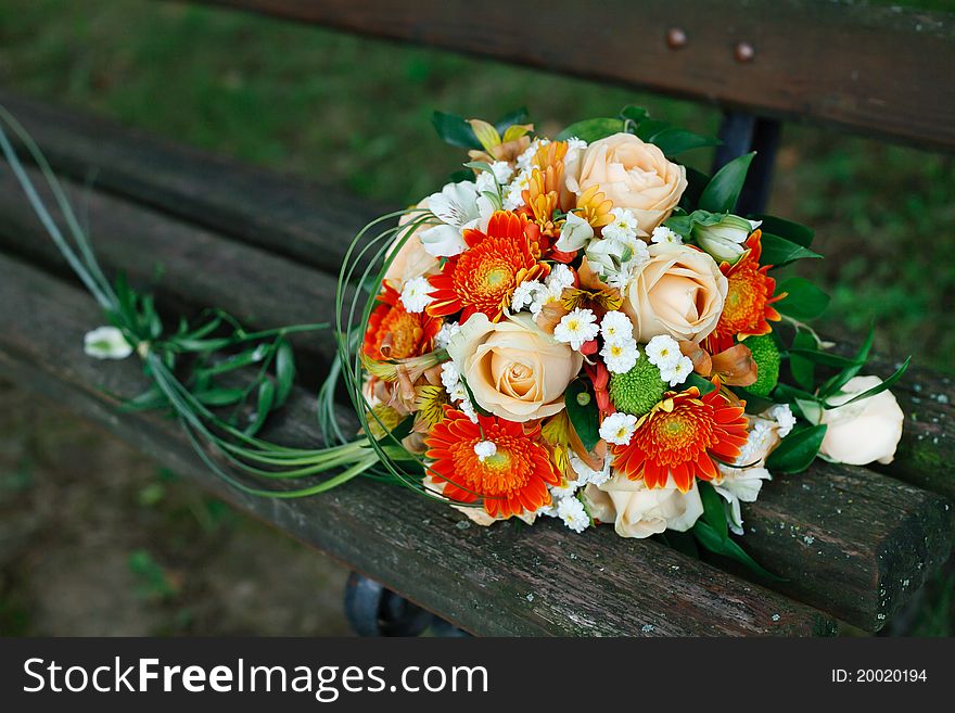 A wonderful bridal bouquet on a park bench.