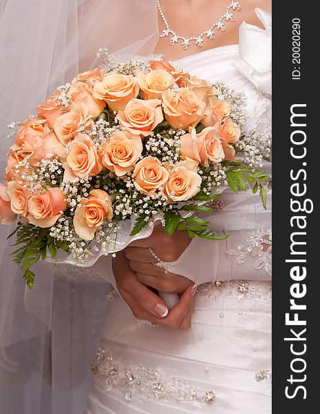 Beautiful bride holding orange bouquet detail