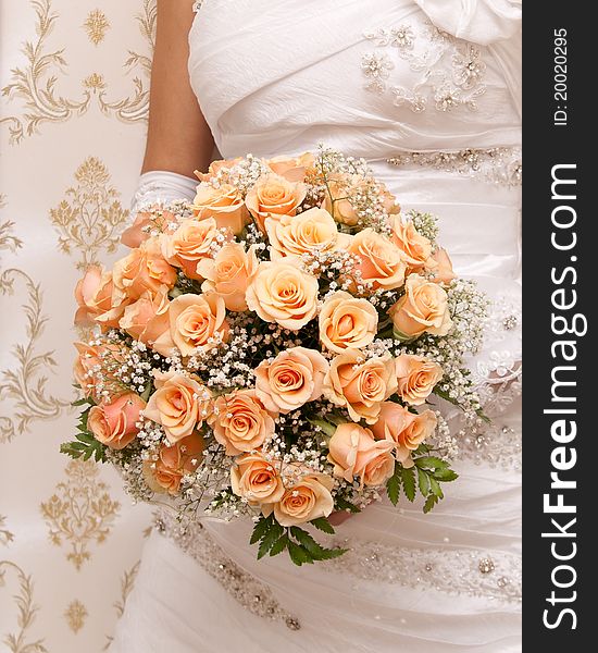 Beautiful bride holding orange bouquet detail
