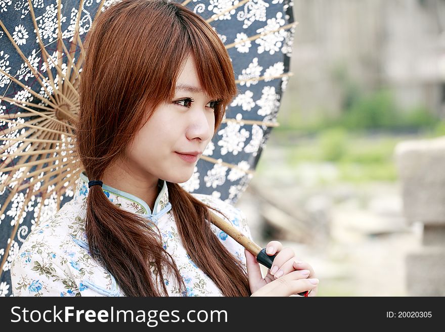 Charming Chinese girl holding the umbrella smiling outdoor. Charming Chinese girl holding the umbrella smiling outdoor.