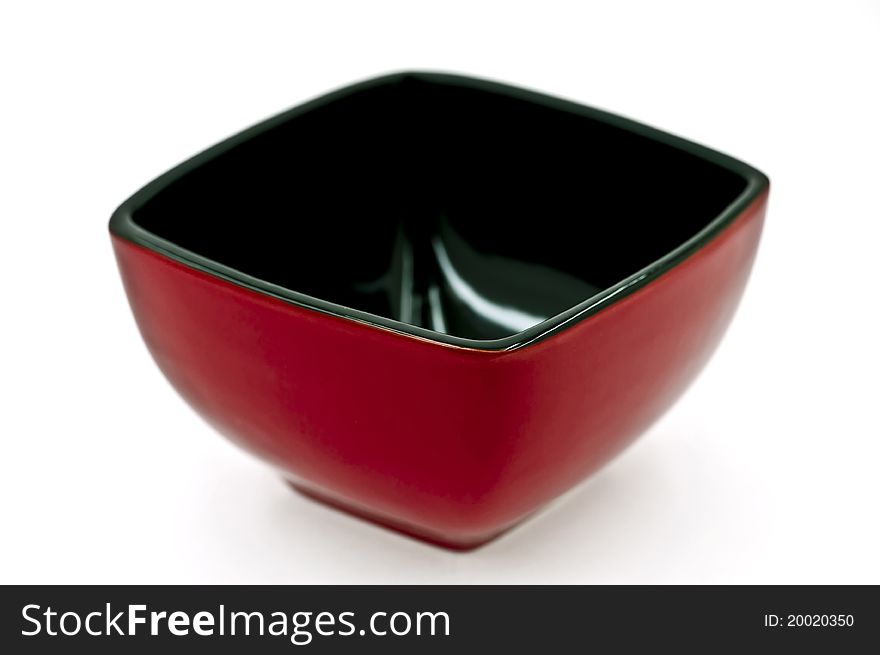 An empty red-black square dish on the white background