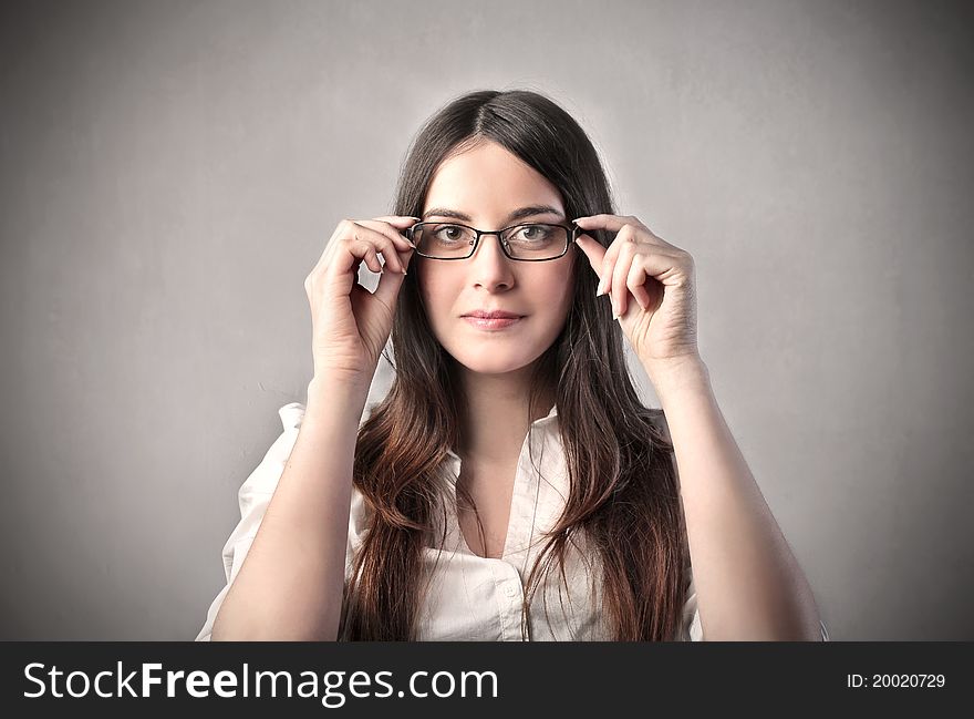 Young businesswoman putting on a pair of glasses