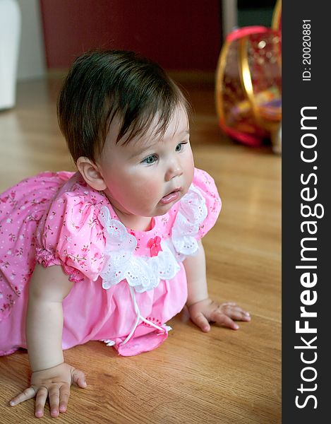 Beautiful little baby in pink dress at home. Shallow DOF