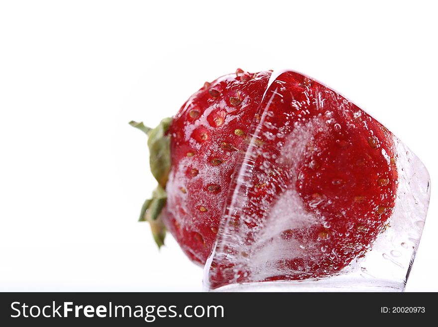 Close up ice cube with frozen strawberry isolated on a white background. Close up ice cube with frozen strawberry isolated on a white background