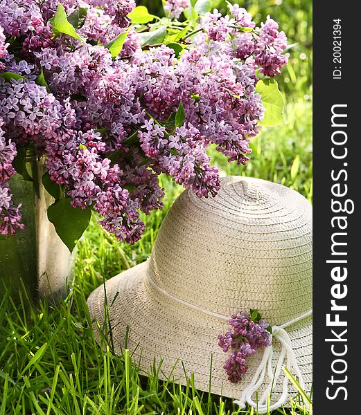 Bunch of lilac  and hat in garden
