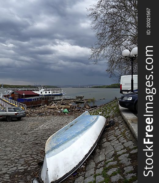 Scene at river bank with old boat and scrap against stormy sky. Scene at river bank with old boat and scrap against stormy sky.