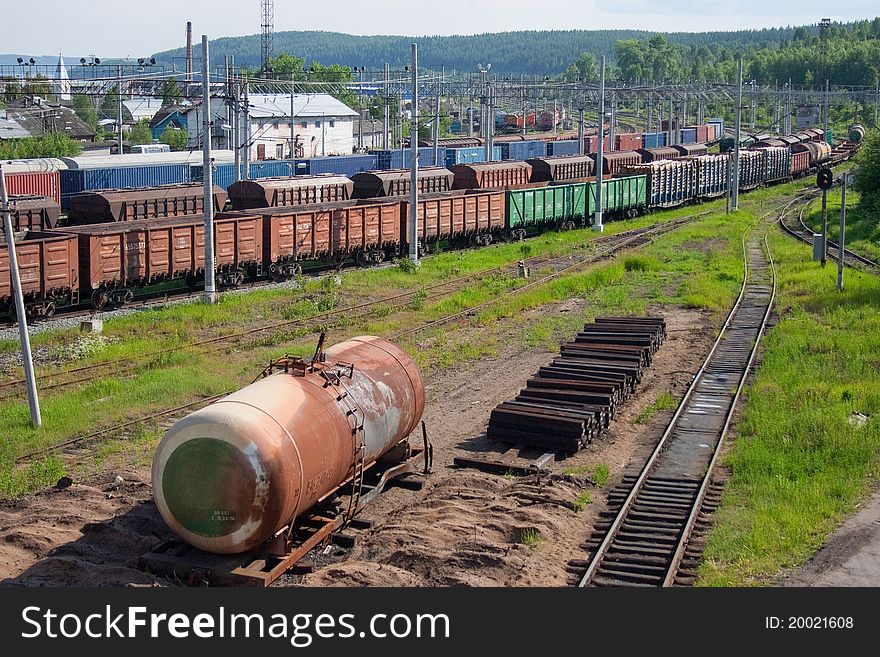 The old rusty tank stands next to the railroad