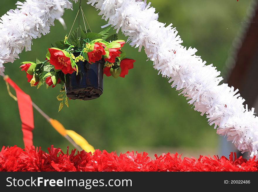 Vase of flowers hanging on top of s.joao festival's decorations