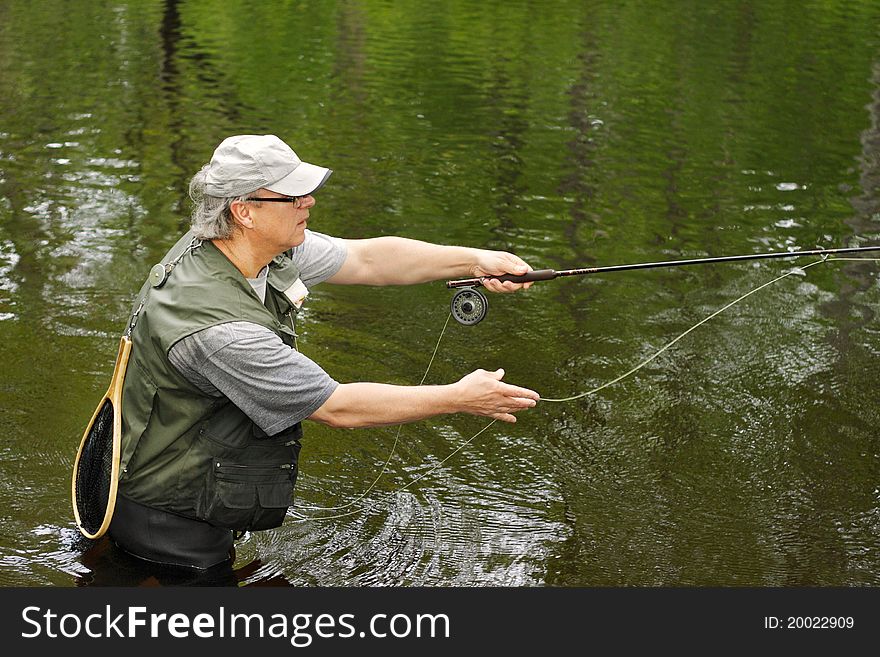 A fly fisherman casts his line. A fly fisherman casts his line