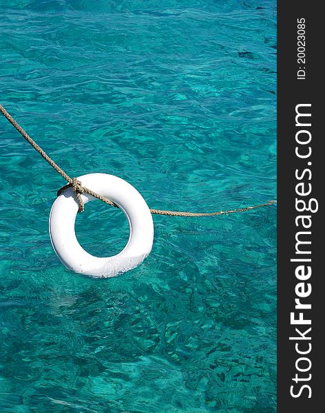 Clasic lifebelt hanging from a rope. On a boat in Catalina island, in Dominican Republic. Clasic lifebelt hanging from a rope. On a boat in Catalina island, in Dominican Republic.