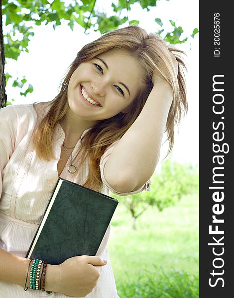 Teenager girl with book in park