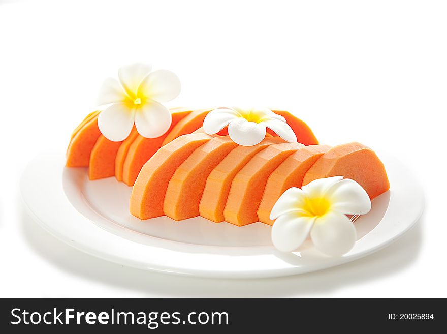 Freshly Diced Papaya with white flowers on white plate isolated on white background. Freshly Diced Papaya with white flowers on white plate isolated on white background