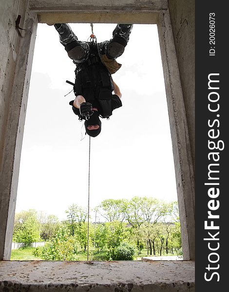 Soldier In Black Mask Hanging On Rope With Pistol