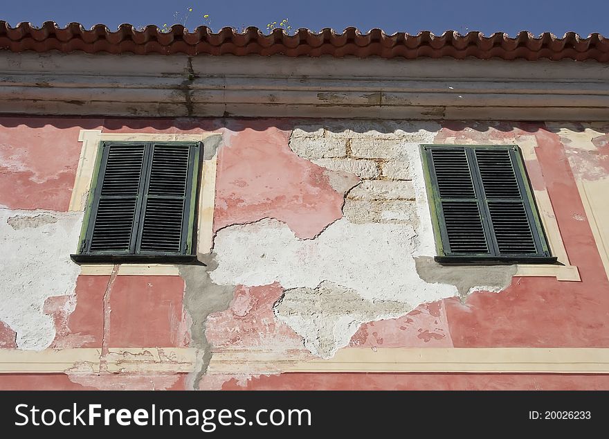 Cracked red plaster and green window blinds, raw. Cracked red plaster and green window blinds, raw