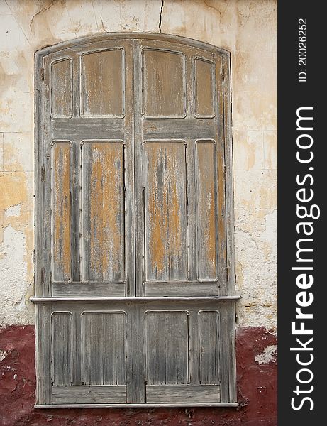 Cracked red plaster and old wooden window blinds raw. Cracked red plaster and old wooden window blinds raw