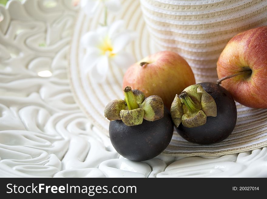 Tropical fruits and apples on summer hat. Tropical fruits and apples on summer hat