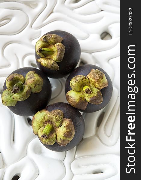 Tropical mangosteens on white bowl