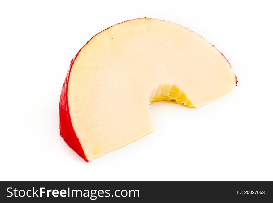 Edam cheese slice with a missing bite isolated on white. Edam cheese slice with a missing bite isolated on white