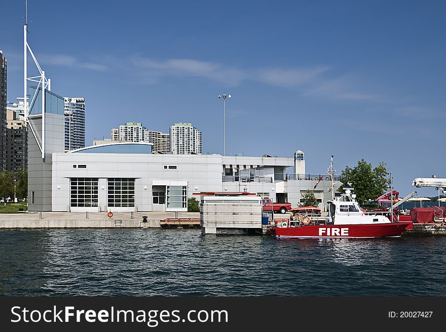 Marine fire station located on the lakefront with a patrol boat docked in foreground. Marine fire station located on the lakefront with a patrol boat docked in foreground.