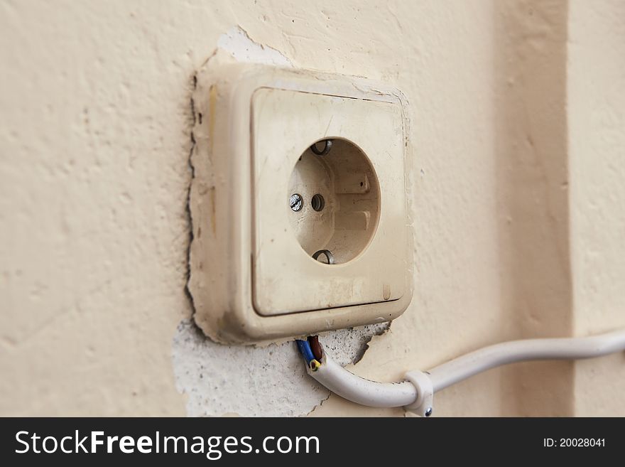 This is a photo of an old and dangerous socket, covered with many layers of paint, and connected externally with a cable. This is a photo of an old and dangerous socket, covered with many layers of paint, and connected externally with a cable.