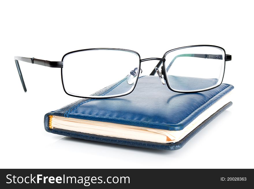 Blue notebook and glasses isolated on a white background