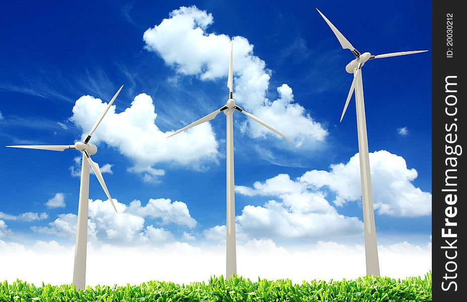 Wind turbines, green wheat fields, clouds & blue sky in spring