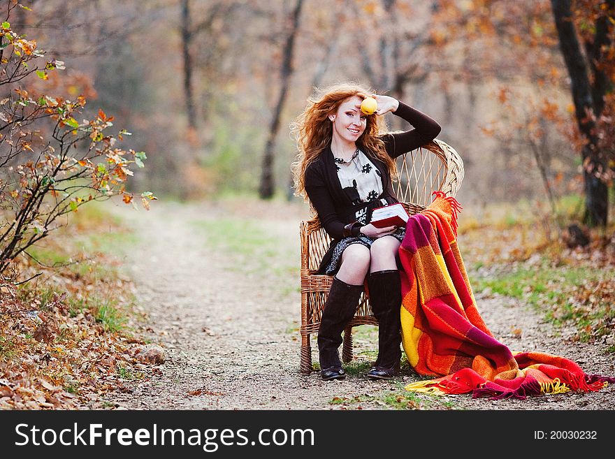 The red-haired girl in autumn leaves outdoor shot