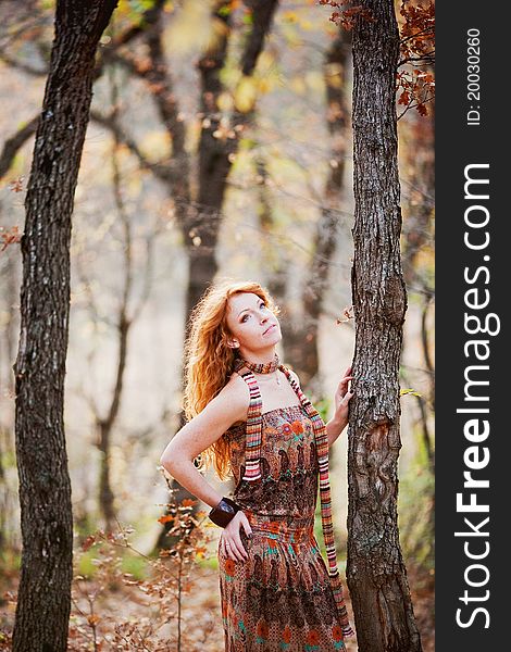 The red-haired girl in autumn leaves outdoor shot