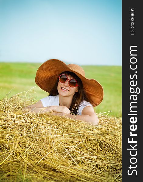 Smiling brunette girl in hat in summer day