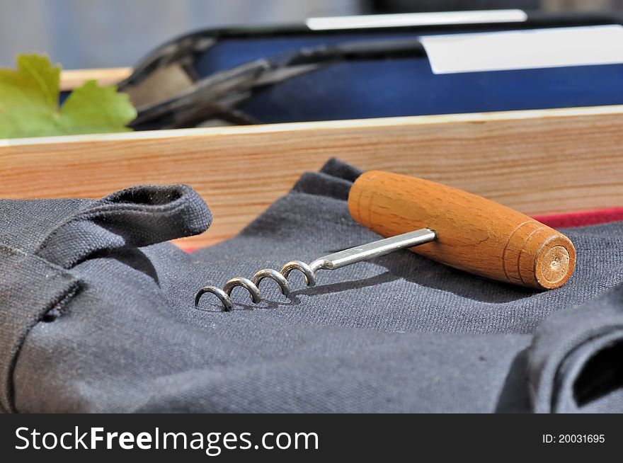 Corkscrew on black apron in a box of wine. Corkscrew on black apron in a box of wine