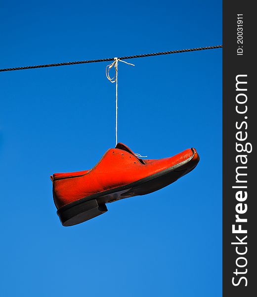 Red shoe in front of blue sky.