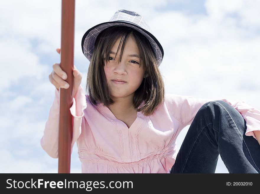 A young girl with a stylish hat in an outdoor setting. A young girl with a stylish hat in an outdoor setting.