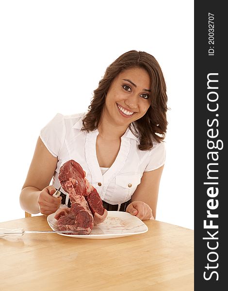 A woman picking up a huge steak off her plate. A woman picking up a huge steak off her plate.