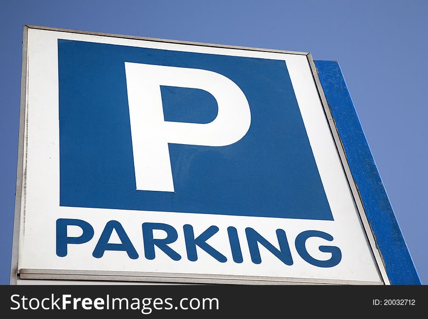 Blue and White Parking Sign against Blue Sky Background