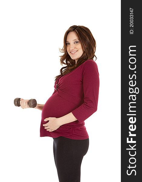 A pregnant woman working out with weights. A pregnant woman working out with weights.