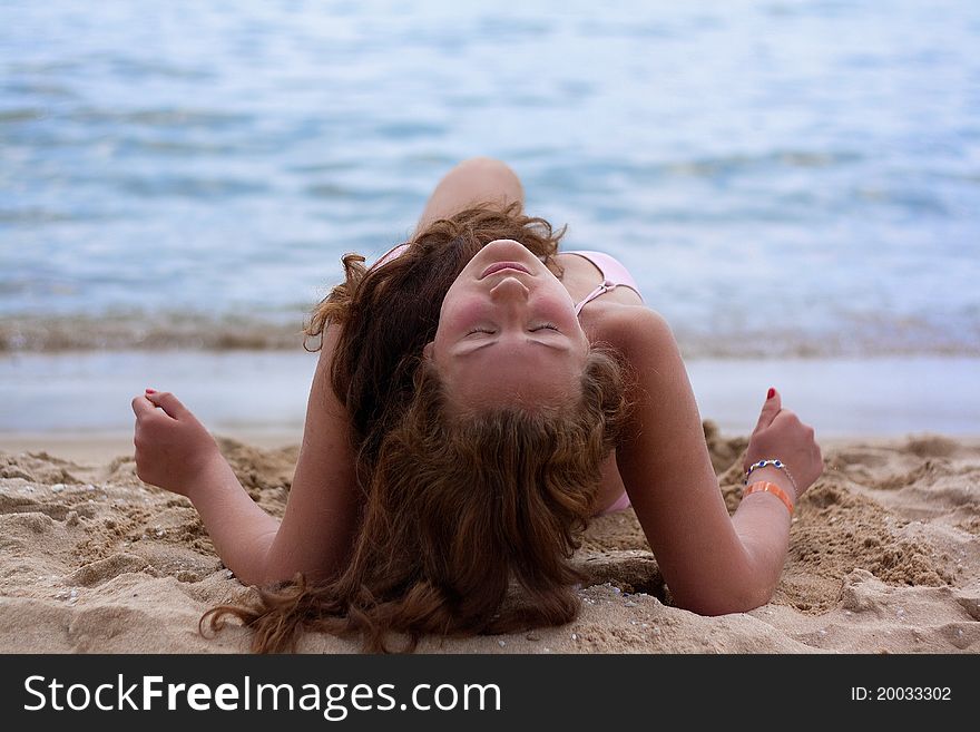 A pretty woman in bikini sunbathing at the beach